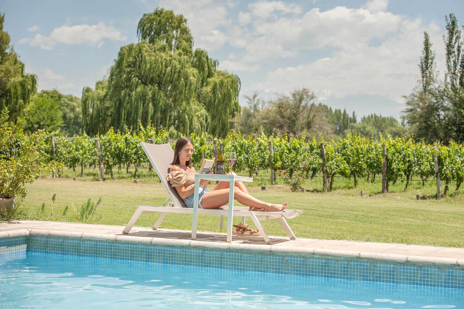 Mujeres leyendo cerca de una pileta frente de la finca de Postales del Nunca Jamás.
